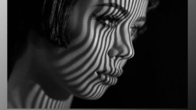 A striking black and white image of a woman's face with short hair illuminated by striped shadows. The shadows create a pattern over her face. The text "INFINITE BLACK & WHITE v1.0.1 Cracked" appears at the bottom along with an infinity symbol.